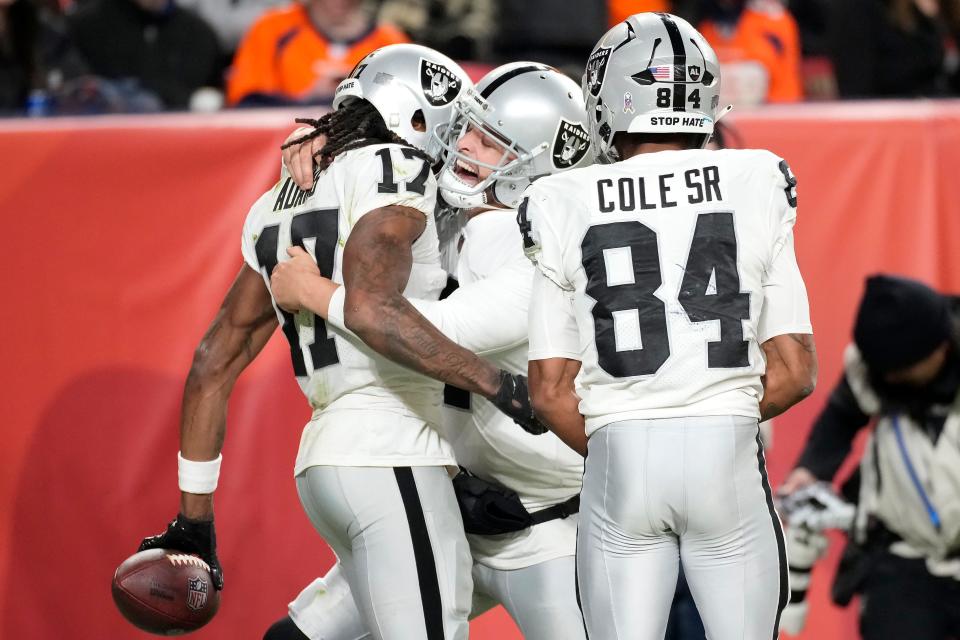 Raiders quarterback Derek Carr, middle, celebrates with wide receiver Davante Adams (17) and wide receiver Keelan Cole (84) after Adams scored the winning touchdown during overtime against the the Denver Broncos.