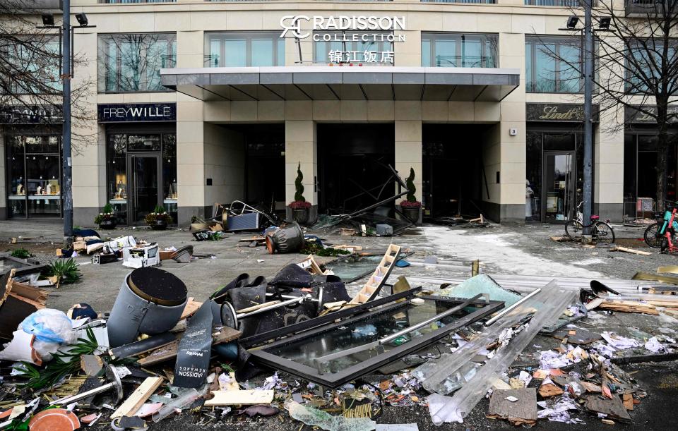 Debris lies in front of the Radisson Blu hotel, where a huge aquarium located in the hotel's lobby burst on December 16, 2022 in Berlin. - The AquaDom aquarium has burst and the leaking water has forced the closure of a nearby street, police and firefighters said. Berlin police said on Twitter that as well as causing 