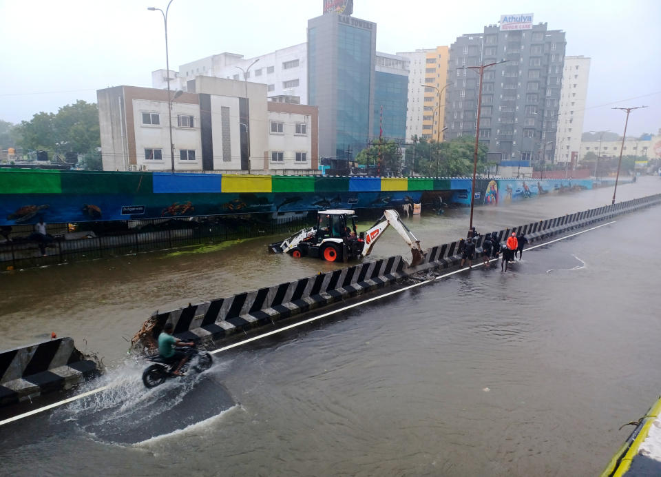 Civic workers at a flooded street following heavy rains along the Bay of Bengal coast in Chennai, India, Monday, Dec.4, 2023. Authorities issued warnings for tropical storm Michuang, which is likely to hit the southern coast on Tuesday with maximum sustained winds of 90-100 kilometers (56-62 miles) per hour with gusts up to 110 kph (68 mph), the Indian Meteorological Department said. (AP Photo)