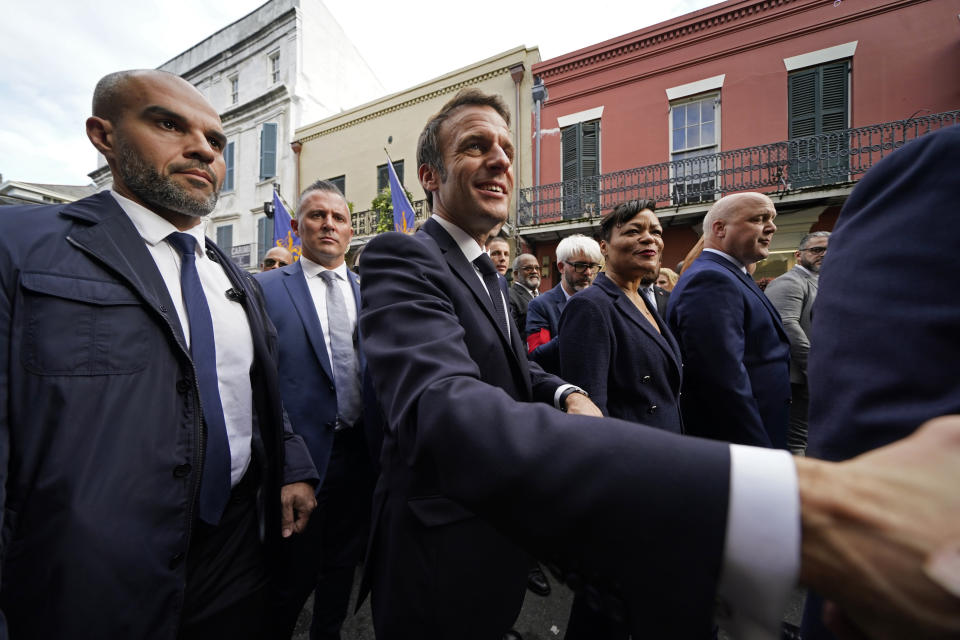 French President Emmanuel Macron greets the crowd as he walks down Royal Street in the French Quarter of New Orleans, Friday, Dec. 2, 2022. (AP Photo/Gerald Herbert)