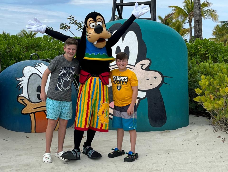 kari's boys posing with goofy on a beach at castaway cay