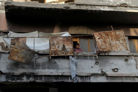 A boy is seen at a balcony in the old city of Homs, Syria July 27, 2017. Picture taken July 27, 2017. REUTERS/Omar Sanadiki