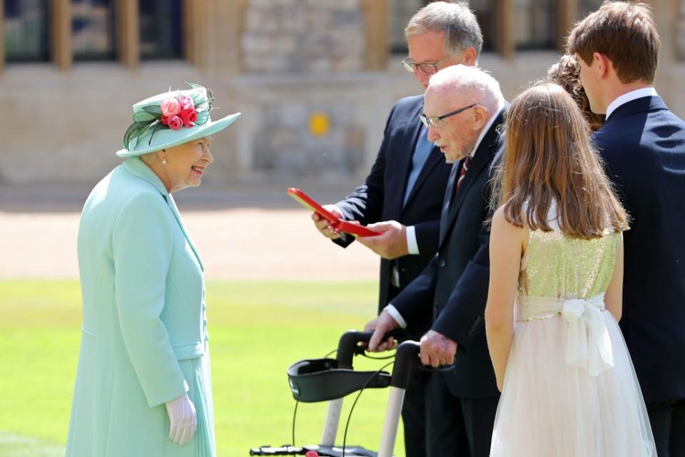 Queen Elizabeth II talking Captain Sir Thomas Moore and his family after awarding his knighthood during a ceremony at Windsor Castle. (PA)