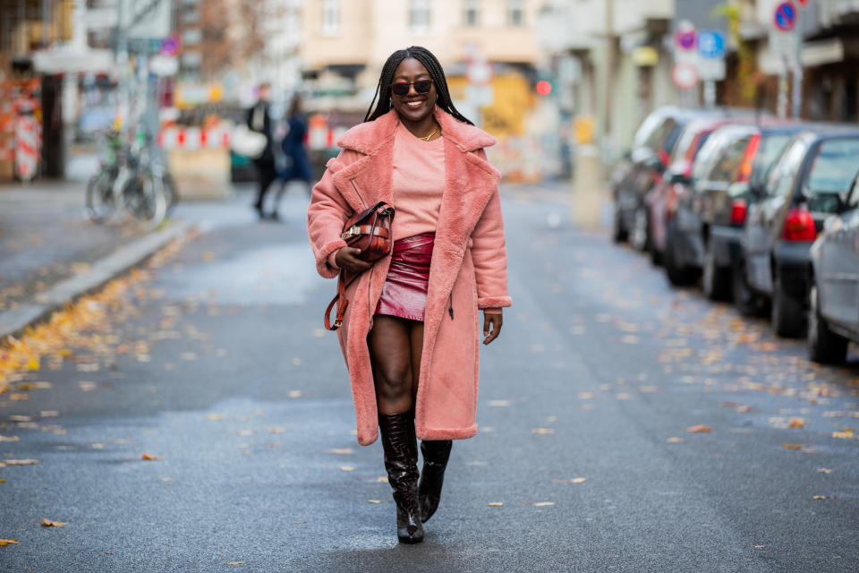 Lois Opoku in a leather skirt, tee shirt, and pink fur jacket