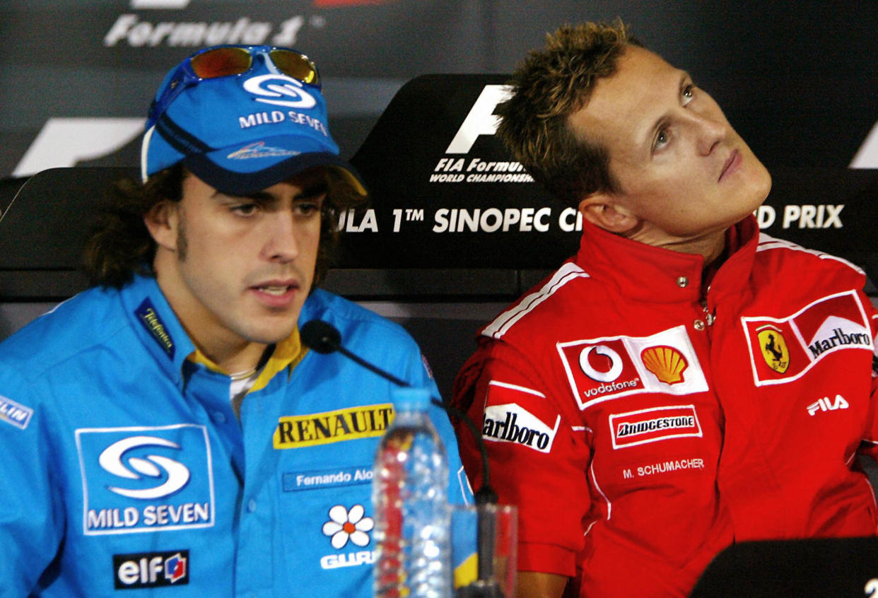 SHANGHAI, CHINA:  Spanish F1 driver Fernando Alonso (L) addresses a press conference as F1 World champion Michael Schumacher of Ferrari looks up, after the first day of the F1 China Grand Prix practice session at the Shaghai International Circuit, 24 September 2004.  China's first F1 Grand Prix will be held 26 September.  AFP PHOTO / Yoshikazu TSUNO  (Photo credit should read YOSHIKAZU TSUNO/AFP via Getty Images)