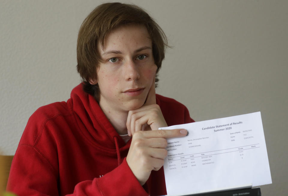 A-Level student and would be medical student Chris Byrne holds up a copy of his teacher predicted results at home in London, Wednesday, Aug. 19, 2020. Thousands of graduating high school students in Britain are scrambling for university places following the government’s disastrous decision to award final grades using an unfair algorithm to replace exams canceled because of the coronavirus, resulting in mass confusion. “I’m stuck waiting,” Byrne said. “There has been no word about if there’s going to be enough medicine places for me to get in this year."(AP Photo/Kirsty Wigglesworth)