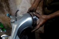 <p>A mechanic puts a headlight on a Vespa scooter, after repairing it at a workshop in Karachi, Pakistan March 1, 2018. (Photo: Akhtar Soomro/Reuters) </p>