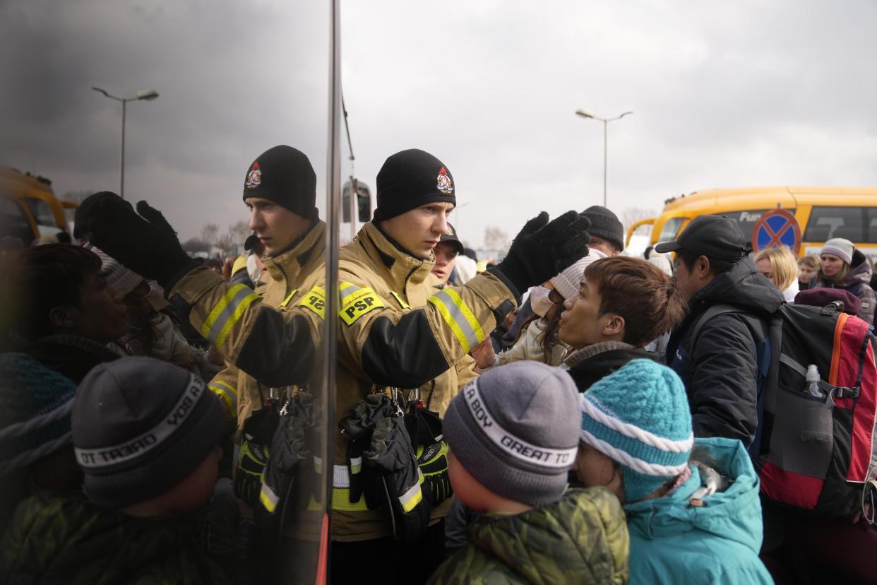 People fleeing from Ukraine queue to board on a bus at the border crossing in Medyka, Poland, Friday, March 4, 2022. More than 1 million people have fled Ukraine following Russia's invasion in the swiftest refugee exodus in this century, the United Nations said Thursday. (AP Photo/Markus Schreiber)