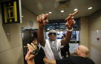 RNPS - PICTURES OF THE YEAR 2013 - Former basketball star Dennis Rodman gestures as he talks to journalists chasing him upon his arrival at Beijing Capital International Airport September 7, 2013. Rodman returned from his second visit to North Korea this year where he again met the reclusive country's leader Kim Jong-un, but did not come back with jailed American missionary Kenneth Bae. REUTERS/Kim Kyung-Hoon (CHINA - Tags: POLITICS SPORT BASKETBALL TPX)