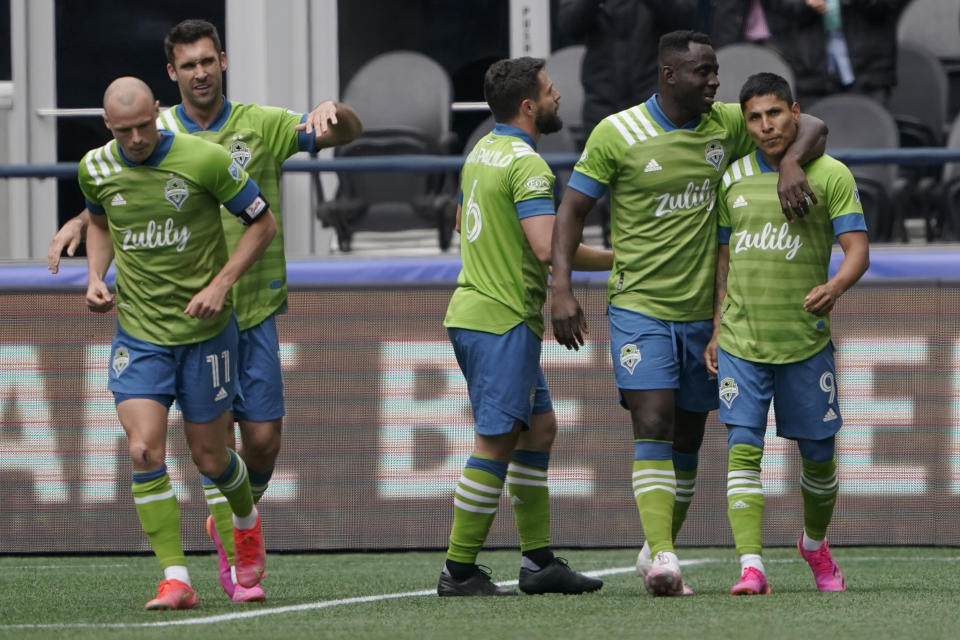 Seattle Sounders forward Raul Ruidiaz, right, is greeted by teammates after he scored a goal against Atlanta United during the first half of an MLS soccer match, Sunday, May 23, 2021, in Seattle. (AP Photo/Ted S. Warren)