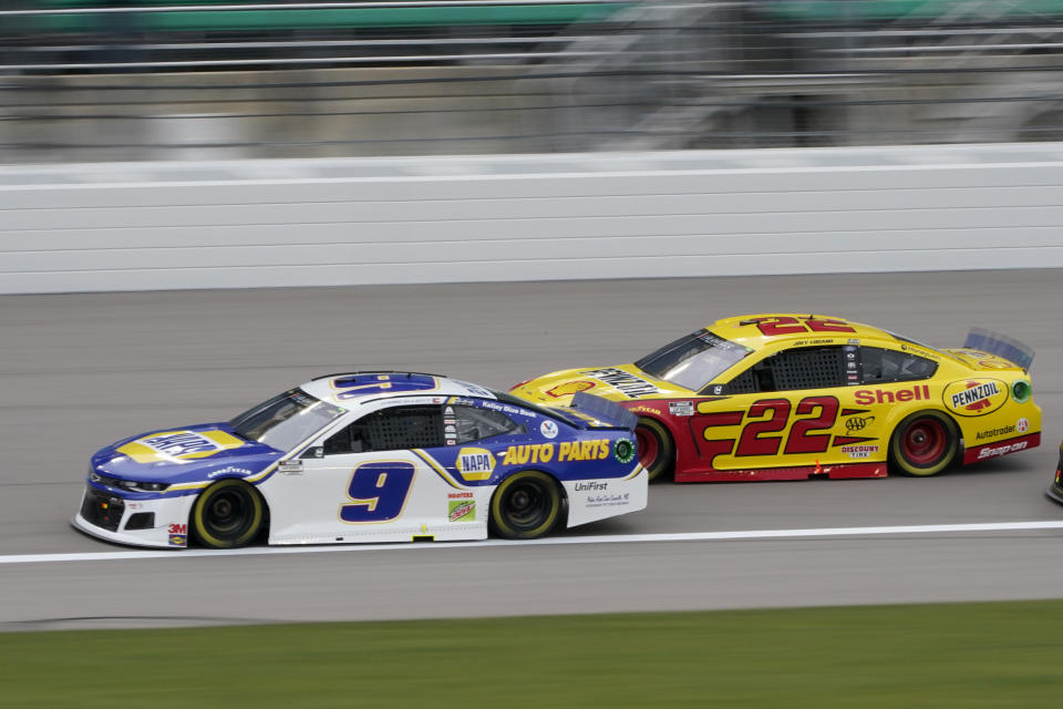 Chase Elliott (9) leads Joey Logano (22) on the first lap of a NASCAR Cup Series auto race at Kansas Speedway in Kansas City, Kan., Sunday, Oct. 18, 2020. (AP Photo/Orlin Wagner)