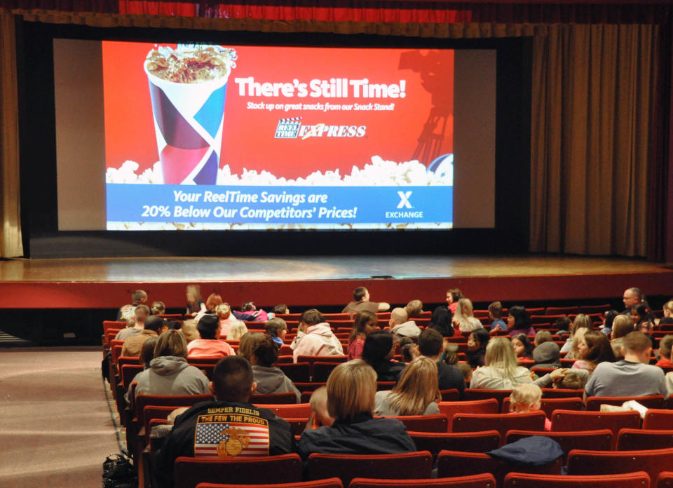 Movie patrons wait for the showing of "Hotel Transylvania" inside the theater on Ellsworth Air Force Base in South Dakota on its last day of operation, Saturday, Jan. 19, 2013. The Army and Air Force Exchange Service theater serving airmen and their families is one of 60 across the globe that's closing because it's too expensive to switch from 35 millimeter film prints to an all-digital projection format. (AP Photo/Dirk Lammers)