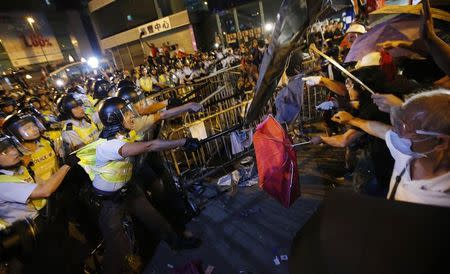 Riot police (L) clash with pro-democracy protesters at the Mongkok shopping district of Hong Kong October 19, 2014. REUTERS/Carlos Barria