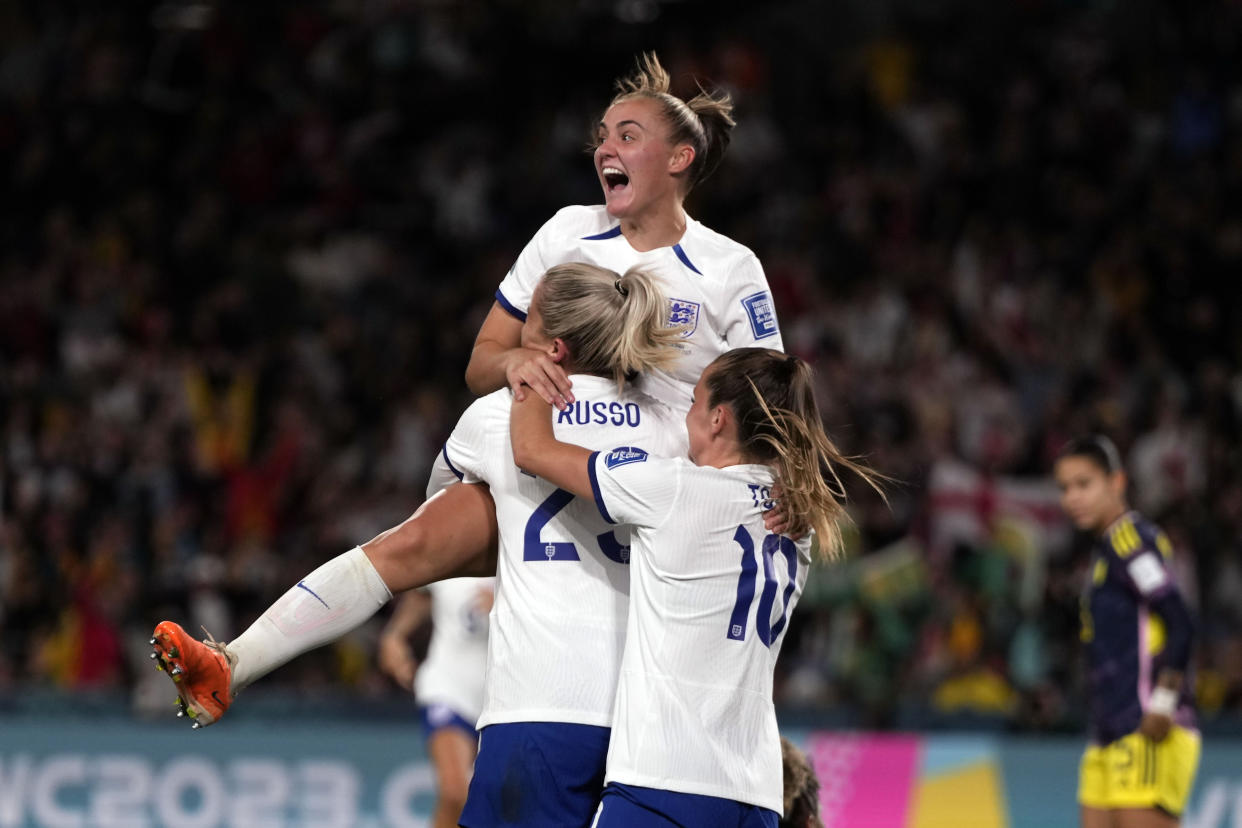 England's Alessia Russo , center, is celebrated after she scored her side's second goal during the Women's World Cup quarterfinal soccer match between England and Colombia at Stadium Australia in Sydney, Australia, Saturday, Aug. 12, 2023. (AP Photo/Mark Baker)