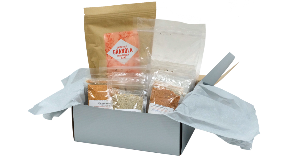 A pantry box by Alta Baja containing packets of granola and spices