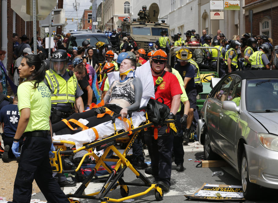 <p>Rescue personnel help injured people after a car ran into a large group of protesters after a white nationalist rally in Charlottesville, Va., Saturday, Aug. 12, 2017. (AP Photo/Steve Helber/AP) </p>