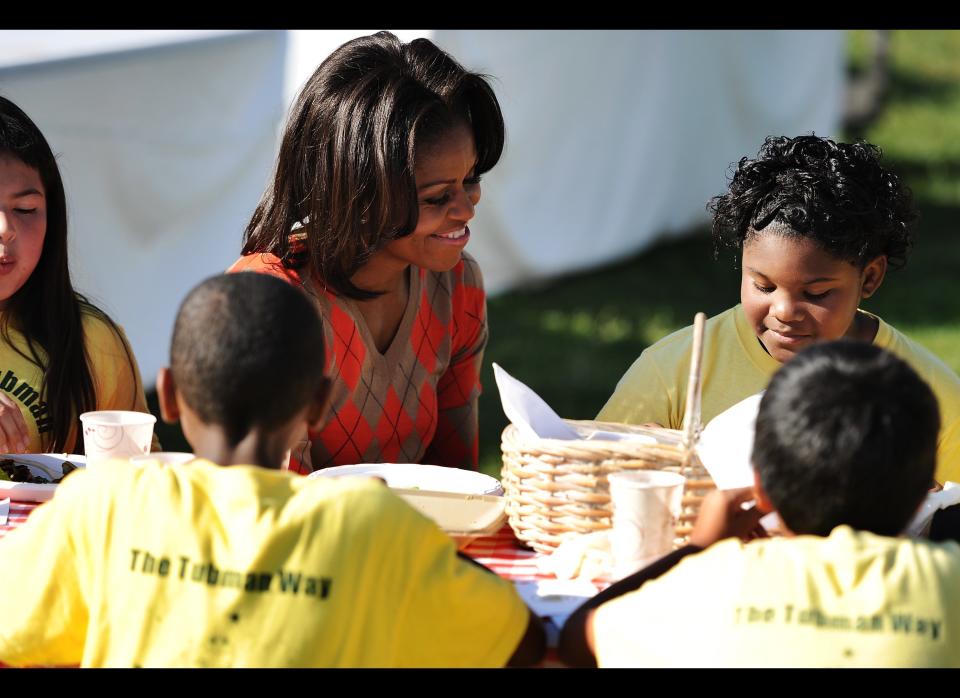 WASHINGTON, DC - OCTOBER 5: U.S. first lady Michelle Obama eats vegetable pizza after harvesting vegetables with local children from Bancroft and Tubman Elementary schools as they participate in the White House Kitchen Garden Fall Harvest, October 5, 2011 at the White House in Washington, DC. Michelle Obama planted the White House kitchen garden to help connect kids with the food they eat as part of her Let's Move! initiative. (Photo by Patrick Smith/Getty Images)