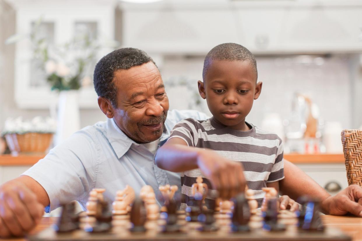 Senior man playing chess with his grandson (8-9), Cape Town, South Africa