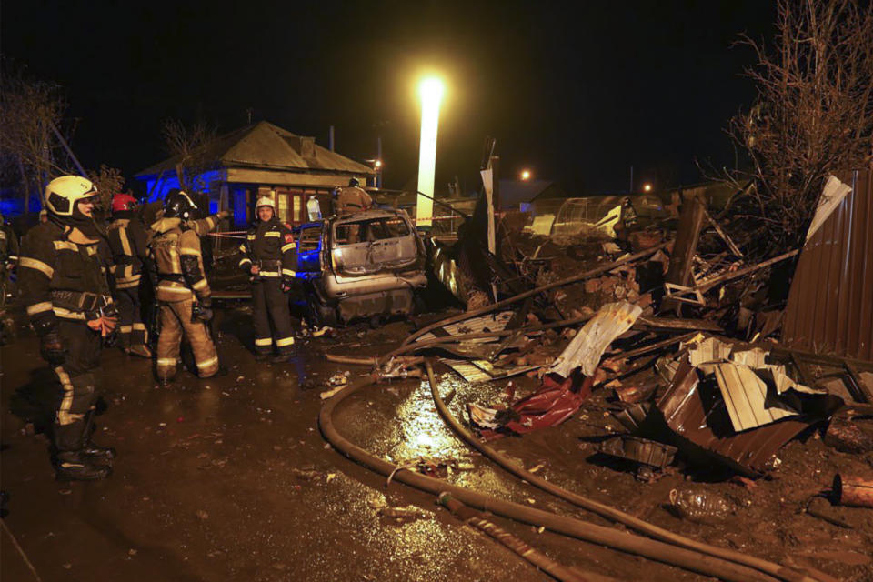 Firefighters work at the scene after a warplane crashed into a residential area in Irkutsk, Russia, Sunday, Oct. 23, 2022. A Russian warplane slammed into a residential building in the Siberian city of Irkutsk Sunday, killing both crewmembers — the second incident in less than a week in which a combat jet has crashed in a residential area. (AP Photo)