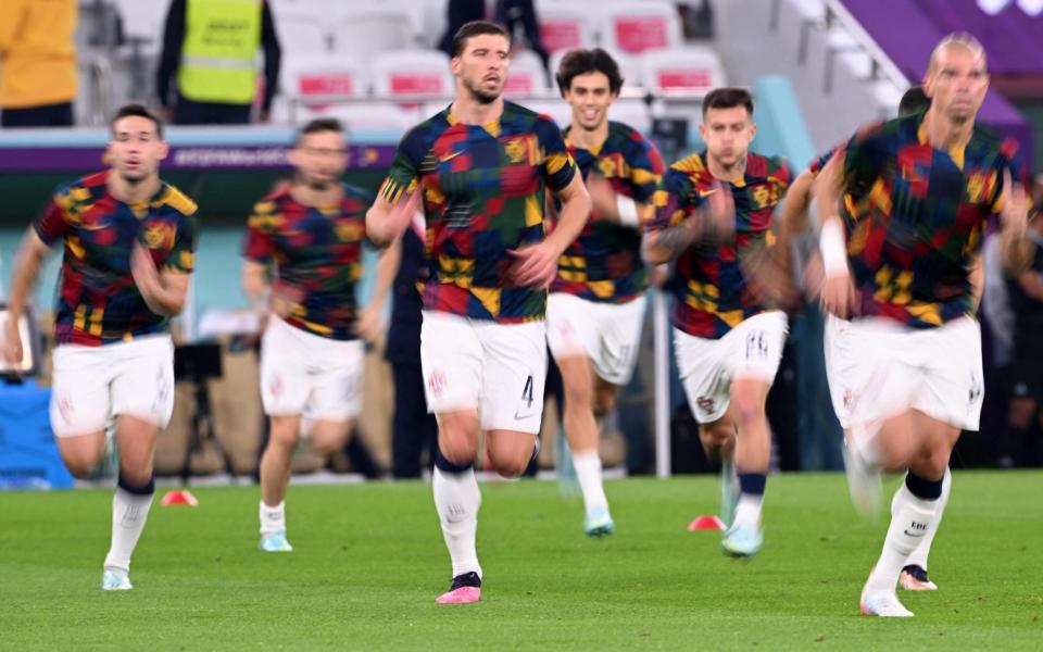 Ruben Dias (C) warms up with teammates before the start of the Qatar 2022 World Cup - AFP