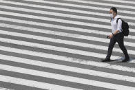 A man wears face mask to help protect against the spread of the new coronavirus passes on a crosswalk in Tokyo, Tuesday, Aug, 4, 2020. (AP Photo/Koji Sasahara)