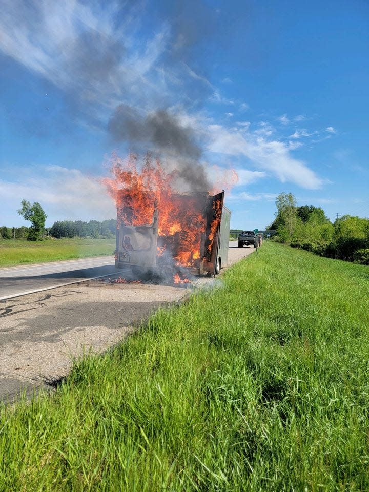 The League of Enchantment Michigan's trailer burns on the side of the road Sunday.