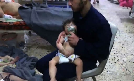 An image grab taken from a video released by the Syrian civil defence in Douma shows unidentified volunteers giving aid to children at a hospital following an alleged chemical attack on the rebel-held town on April 8, 2018
