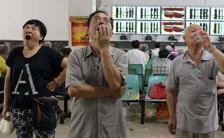 Investors look at computer screens showing stock information at a brokerage house in Wuhan, Hubei province, China, July 3, 2015. REUTERS/China Daily