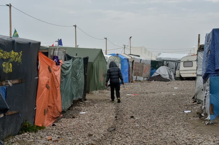 A migrant walks in the "Jungle" camp in Calais, northern France, early on October 24, 2016