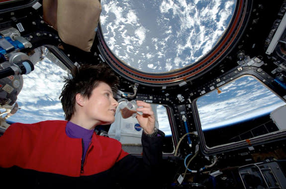 Astronaut Samantha Cristoforetti enjoys the first cup of coffee to be brewed on the space station.