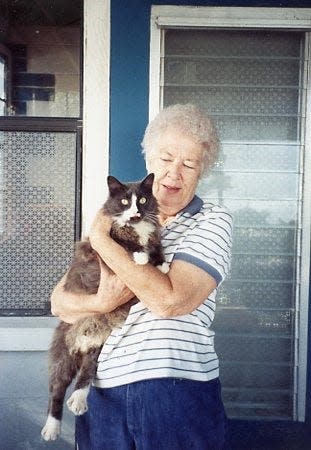 Weona Cleveland holds one of her cats on the porch of her longtime Melbourne home.