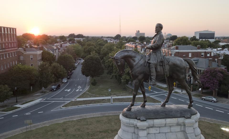 In this July 31, 2017 photo, the sun sets behind the statue of confederate General Robert E. Lee on Monument Avenue in Richmond, Va. Virginia has become more diverse and socially liberal in recent years. But the state continues to struggle with mindsets shaped by its turbulent racial history. When a racist photo was discovered last week on Gov. Ralph Northam’s 1984 medical school yearbook page, it exposed how much deeply embedded racism still lurks in the state. (AP Photo/Steve Helber)