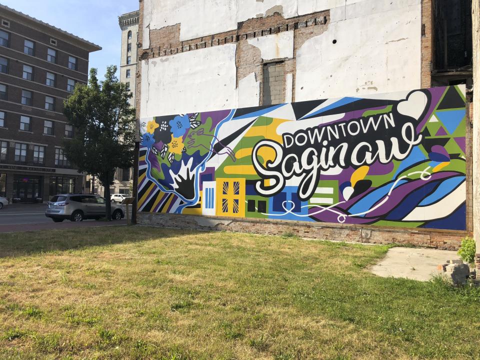 In this July 17, 2019 photo, a mural welcomes visitors to downtown Saginaw, Michigan. The city has been working for decades to reinvent itself after the decline of the auto industry, with mixed results. President Donald Trump is campaigning on the improved economy as he seeks re-election, while Democrats argue not everyone has enjoyed the benefits. Economic conditions in Michigan could be crucial in determining whether Democrats retake a state they once held for decades (AP Photo/Sara Burnett)