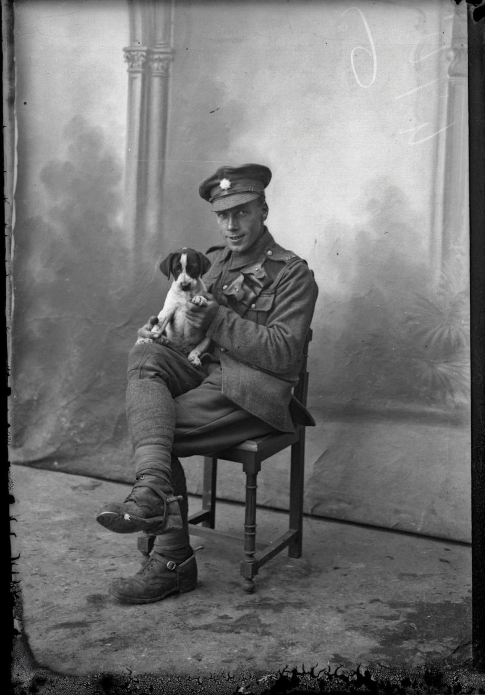 <p>An unidentified soldier cuddles a puppy on his lap. The same pup features in numerous pictures in the collection, and so is resumed to be a local favourite. (Courtesy Kerry Stokes Collection, The Louis and Antoinette Thuillier Collection) </p>