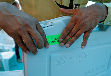 A member of election staff pastes a tag on an Electronic Voting Machine (EVM) at a distribution centre ahead of India's general election, in Ahmedabad, India, March 26, 2019. REUTERS/Amit Dave