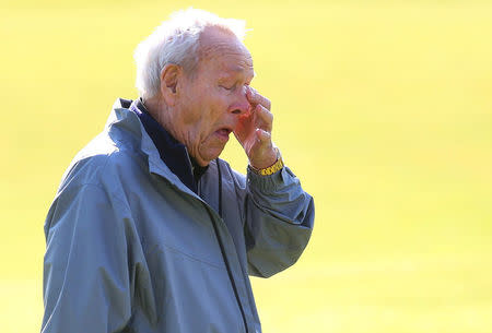 Arnold Palmer wipes his eye on the 18th green during the Champion Golfers' Challenge tournament ahead of the British Open golf championship on the Old Course in St. Andrews, Scotland. REUTERS/Eddie Keogh