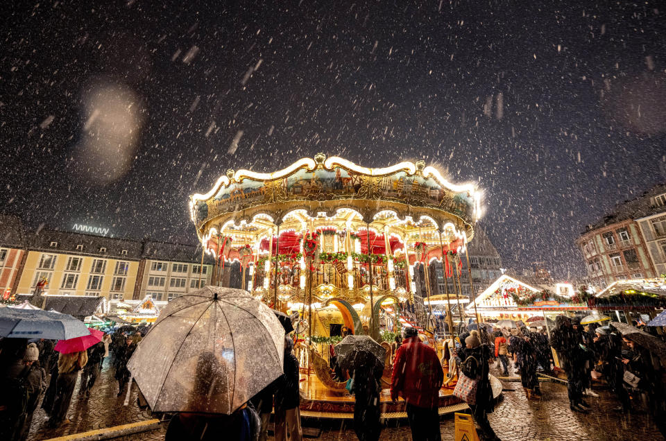 Snow falls as the traditional Christmas market with the merry-go-round was opened in Frankfurt, Germany, Monday, Nov. 27, 2023. (AP Photo/Michael Probst)