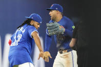 Toronto Blue Jays first base Vladimir Guerrero Jr. (27) and teammate George Springer, right, celebrate after defeating the Colorado Rockies in baseball game action in Toronto, Sunday, April 14, 2024. (Frank Gunn/The Canadian Press via AP)