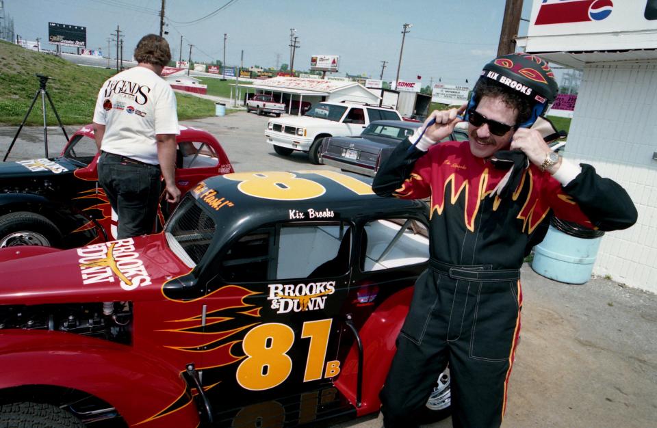 Kix Brooks of Brooks and Dunn puts on his racing helmet during the taping of CBS special, "A Day in the Life of Country Music," at the Nashville Motor Speedway May 7, 1993. Brooks and Dunn regular competes in mini race cars at the track.