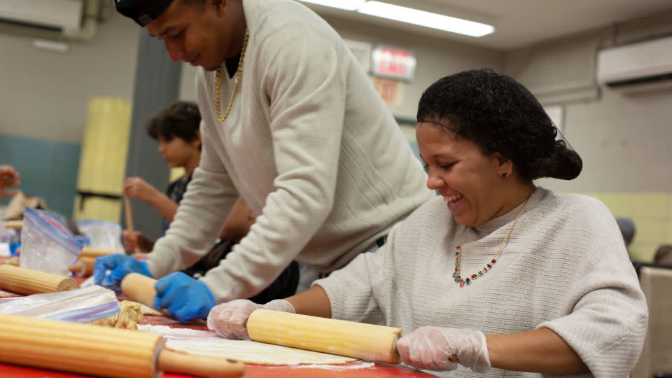 Franklin Jose Rivero, left, and Lucelys Garcia roll out dough for Thanksgiving pies. - Laura Oliverio/CNN