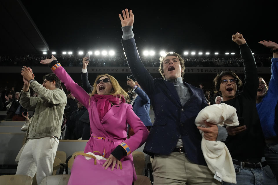 Spectators cheer as Spain's Rafael Nadal celebrates winning his quarterfinal match against Serbia's Novak Djokovic in four sets, 6-2, 4-6, 6-2, 7-6 (7-4), at the French Open tennis tournament in Roland Garros stadium in Paris, France, Wednesday, June 1, 2022. (AP Photo/Christophe Ena)