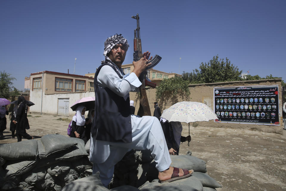 An Afghan volunteer stands guard outside a mosque during a memorial service for the victims of the Dubai City wedding hall bombing in Kabul, Afghanistan, Tuesday, Aug. 20, 2019. Hundreds of people have gathered in mosques in Afghanistan's capital for memorials for scores of people killed in a horrific suicide bombing at a Kabul wedding over the weekend. (AP Photo/Rafiq Maqbool)