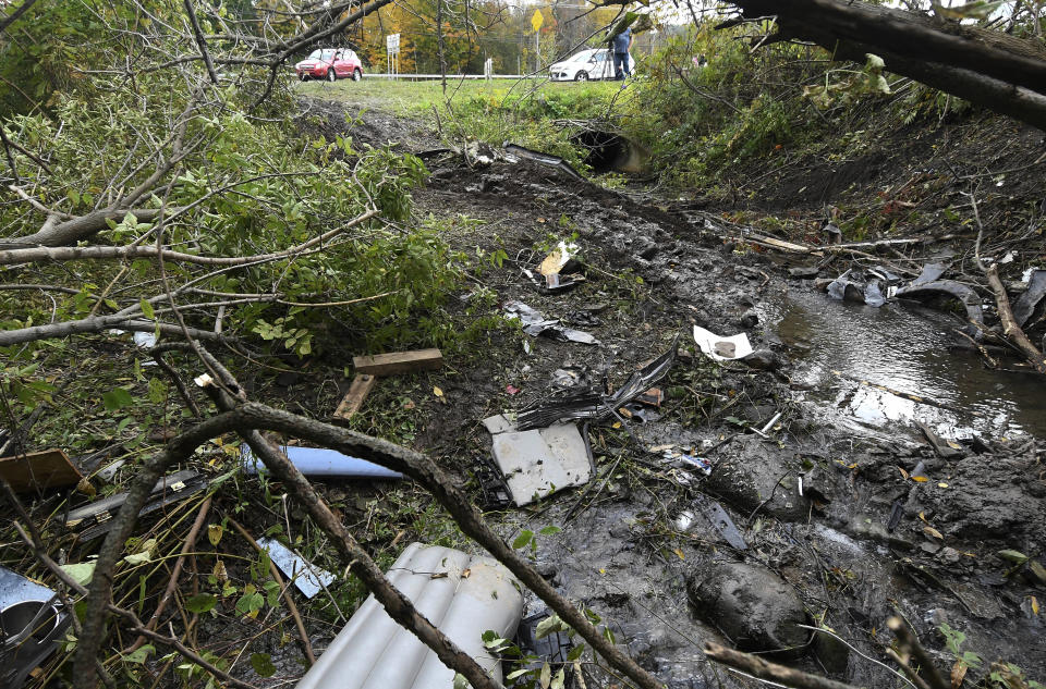 Debris scatters an area at the site of yesterday’s fatal crash. Image: AP