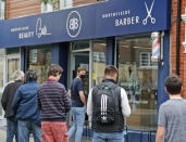 People queue outside Northfields Barber as it opens for the first time after the COVID-19 lockdown in London, Saturday, July 4, 2020. England is embarking on perhaps its biggest lockdown easing yet as pubs and restaurants have the right to reopen for the first time in more than three months. In addition to the reopening of much of the hospitality sector, couples can tie the knot once again, while many of those who have had enough of their lockdown hair can finally get a trim. (AP Photo/Frank Augstein)