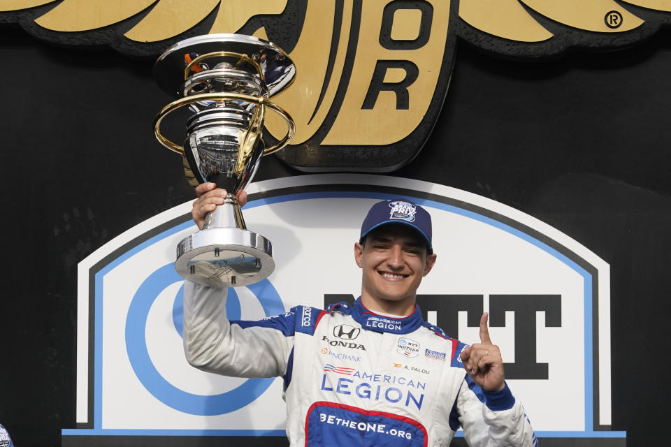 Alex Palou, of Spain, holds the trophy after winning the IndyCar Grand Prix auto race at Indianapolis Motor Speedway, Saturday, May 13, 2023, in Indianapolis. (AP Photo/Darron Cummings)