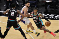 Memphis Grizzlies guard Ja Morant (12) drives around Philadelphia 76ers guard Ben Simmons during the second half of an NBA basketball game Saturday, Jan. 16, 2021, in Memphis, Tenn. (AP Photo/Brandon Dill)