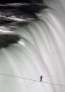 Nik Wallenda walks over Niagara Falls on a tightrope in Niagara Falls, Ontario, on Friday, June 15, 2012. Wallenda has finished his attempt to become the first person to walk on a tightrope 1,800 feet across the mist-fogged brink of roaring Niagara Falls. The seventh-generation member of the famed Flying Wallendas had long dreamed of pulling off the stunt, never before attempted. (AP Photo/The Canadian Press, Frank Gunn)