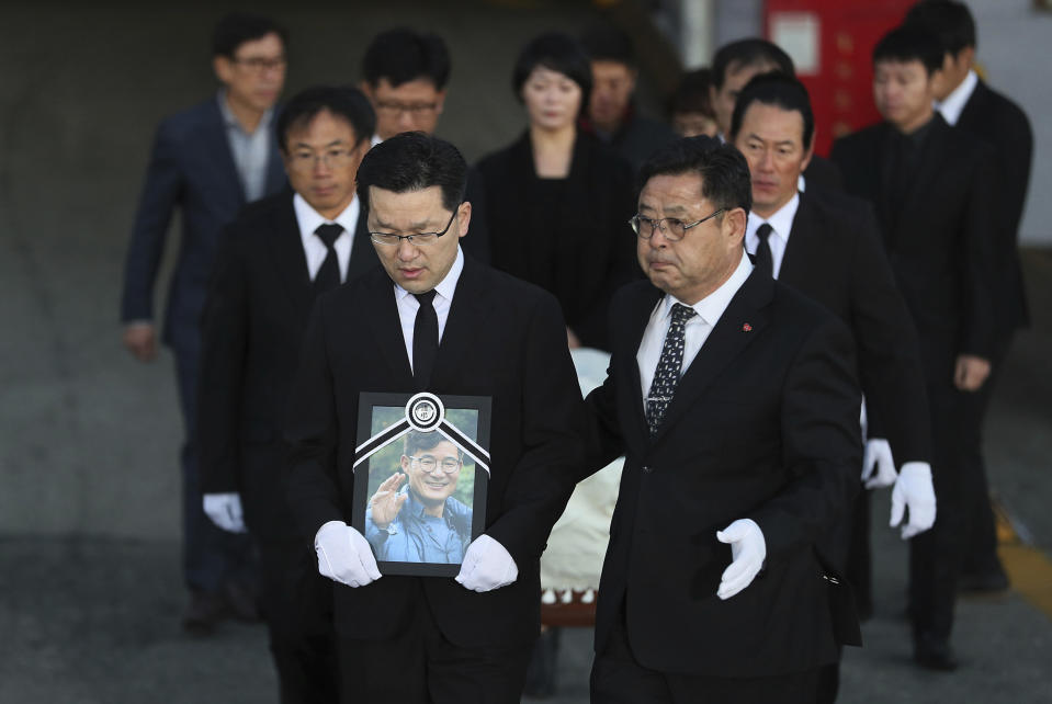 Relatives and friends of the late mountain climber Kim Chang-ho carry his portrait and the casket containing his body from a cargo terminal at Incheon International Airport in Incheon, South Korea, Wednesday, Oct. 17, 2018. Relatives dressed in black funeral suits wept in grief on Wednesday as the bodies of five South Korean mountain climbers arrived home from Nepal where they had died in a storm last week. (Lee Ji-eun/Yonhap via AP)