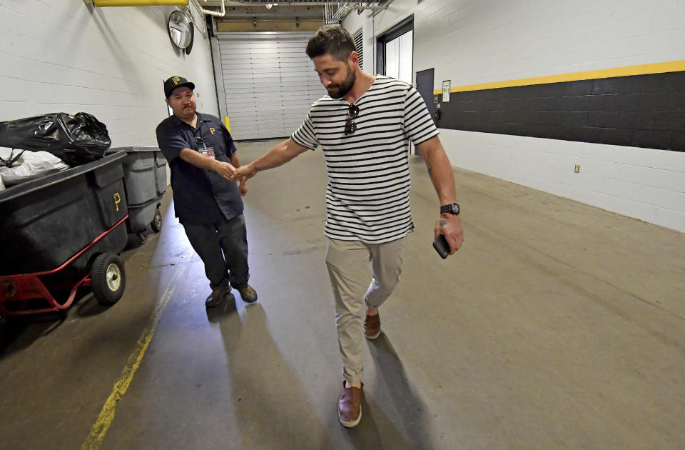Pittsburgh Pirates catcher Francisco Cervelli shakes hands with cleaning crew member Steve Tapia as he heads to his car after leaving the clubhouse Thursday, Aug. 22, 2019, in Pittsburgh. The team had requested his unconditional release on waivers earlier in the day. (Matt Freed/Pittsburgh Post-Gazette via AP)