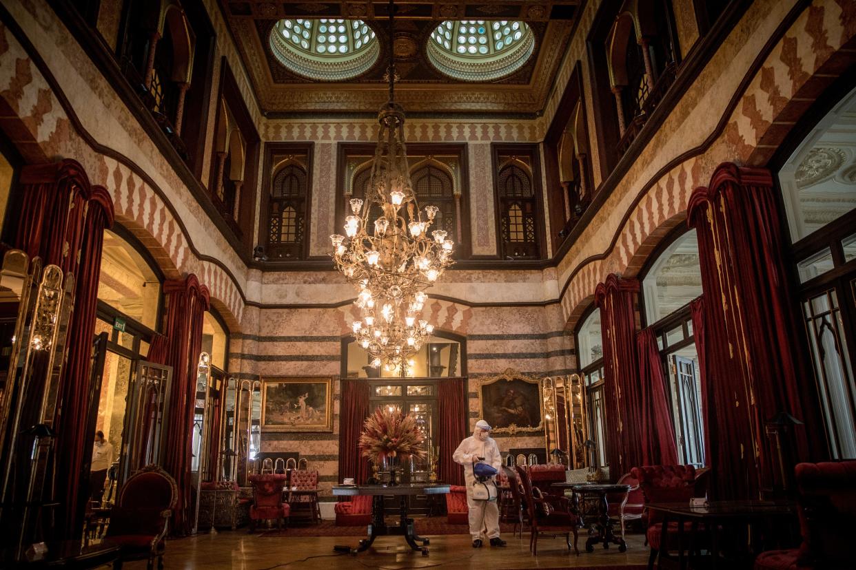 A hotel employee disinfects the lobby of Istanbul's historic Pera Palace Hotel on July 4, 2020, in Istanbul, Turkey. After being closed for more than three months the famous hotel reopened on June 26 under new coronavirus restrictions. After each stay rooms are cleaned and disinfected and left for 12 hours before new guests can enter, air conditioning units were altered with new filters, masks and hand sanitizer are supplied throughout the hotel.